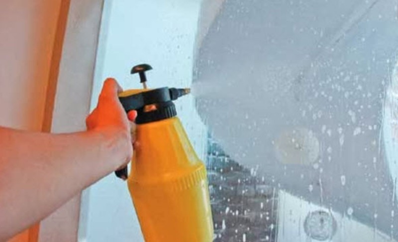 Xịt đều hỗn hợp nước xà phòng loãng lên toàn bộ diện tích kính cần dán